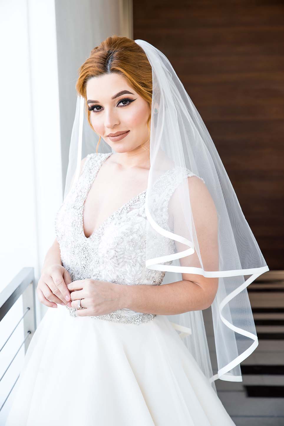 Model wearing white wedding dress and veil