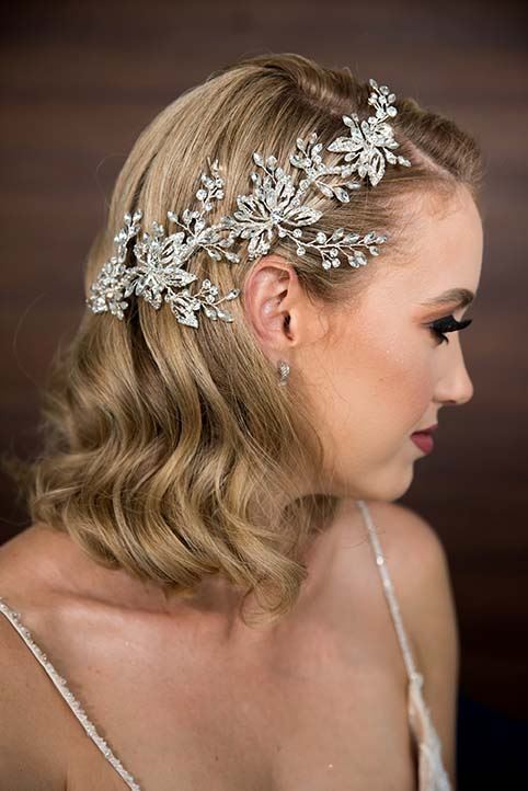 Model wearing white wedding dress and a floral hairpiece